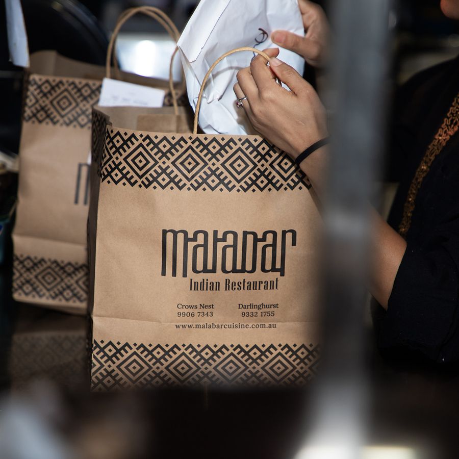 A Malabar takeaway bag being packed at the counter