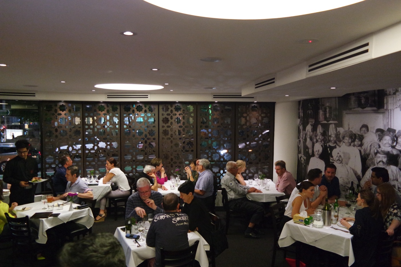 Diners at white-clothed tables in the Malabar dining room on an evening.